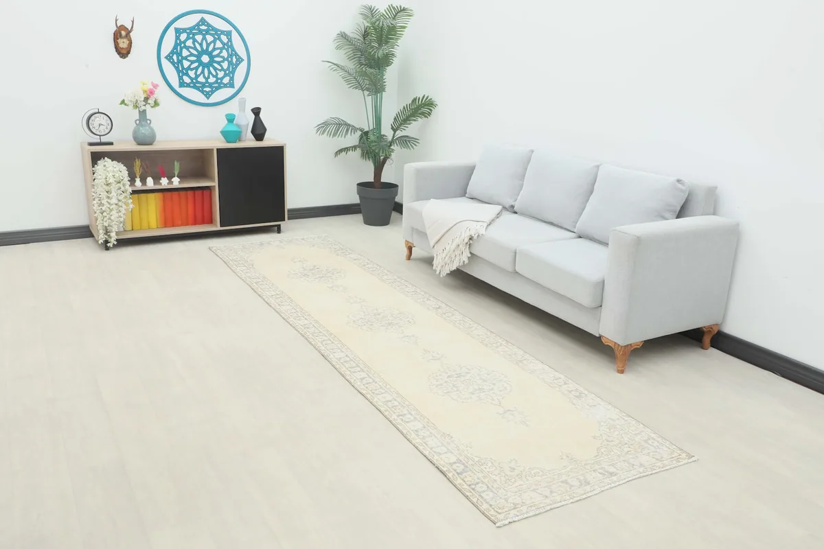 Vintage Anatolian runner rug displayed in a modern living room setting with a light sofa.