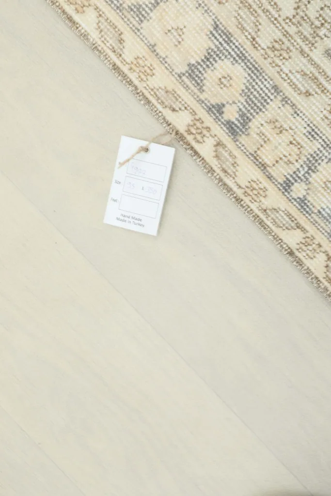 Product tag on the rug's corner, indicating its origin and material.