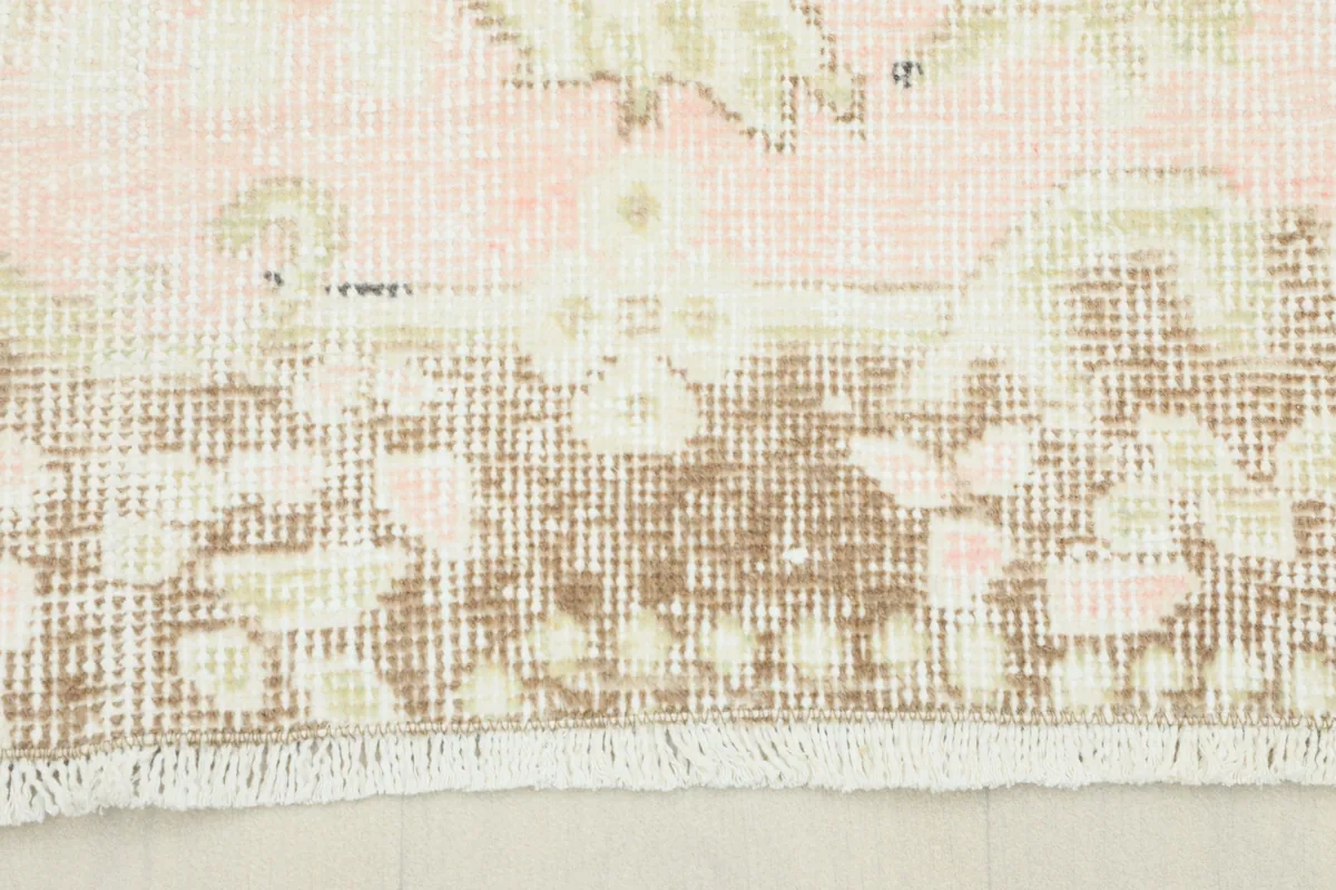 Close-up of the Soft Rose Floral Medallion Rug's border, showing faded rose and brown tones.