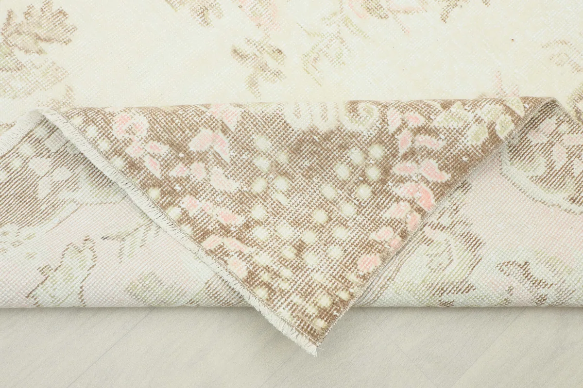 Folded corner of the Soft Rose Floral Medallion Rug, revealing the reverse side of the hand-knotted pile.