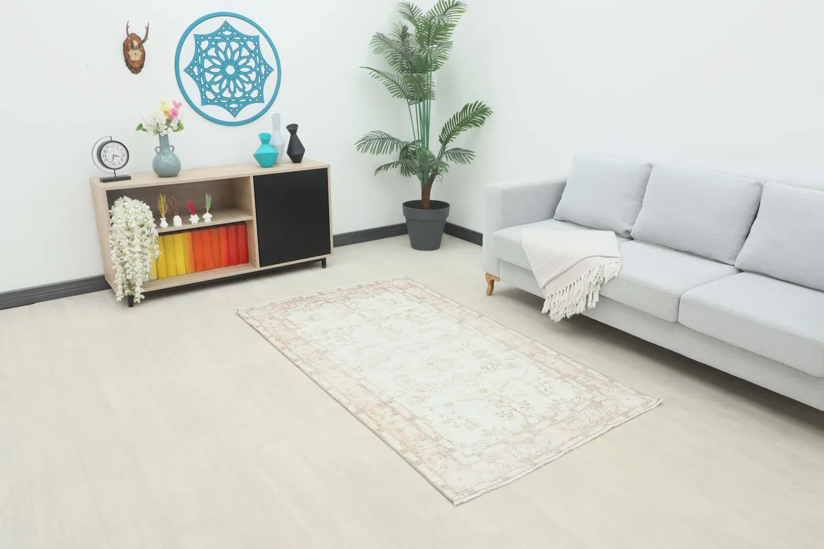 Ivory and rose vintage rug styled in a modern living room setting.