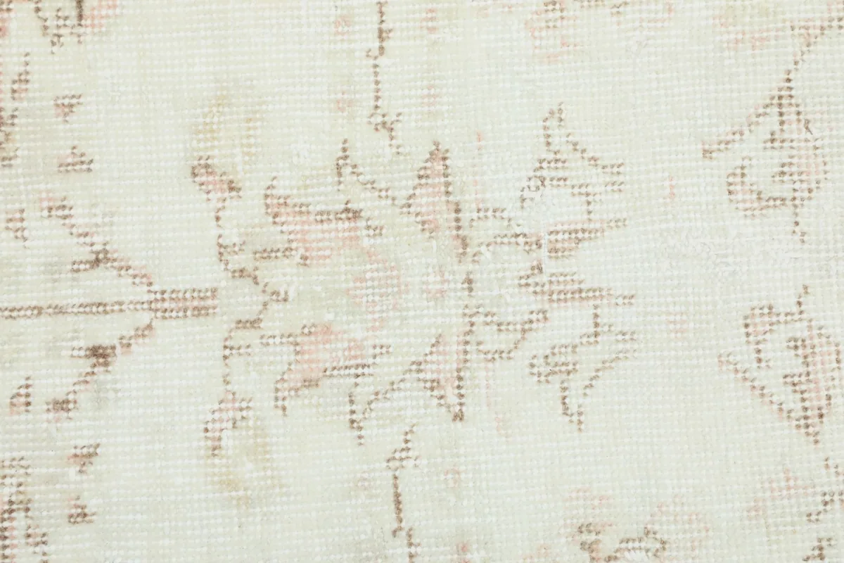 Detailed close-up of the hand-knotted wool pile and subtle floral pattern.