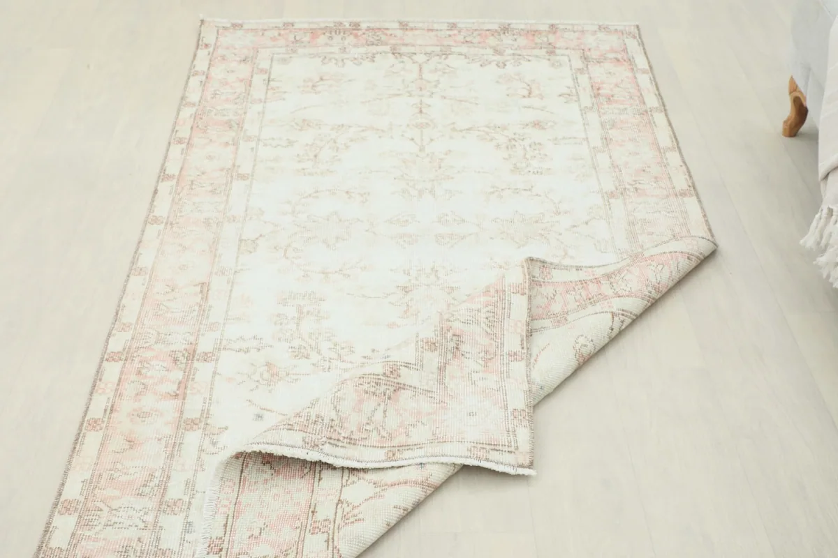 Rug partially folded, revealing the flexibility and texture of the vintage wool.