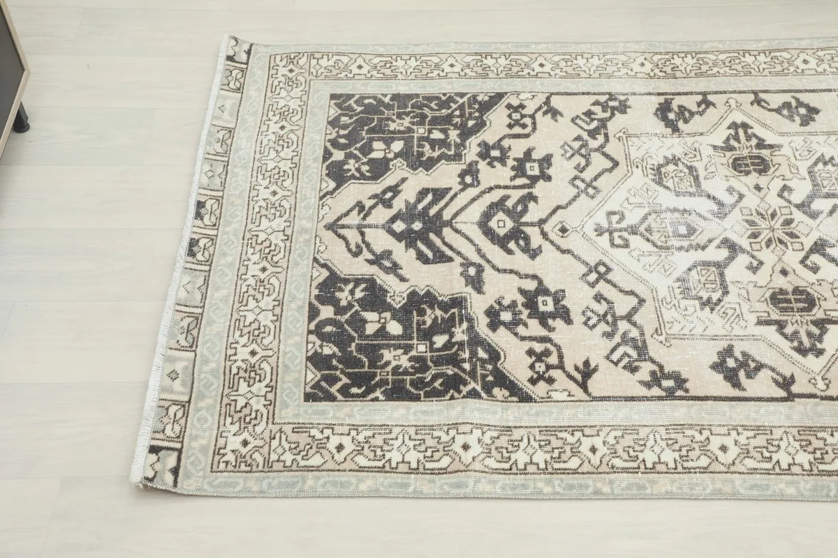 Angled view showing the rug's corner and part of its central design next to furniture