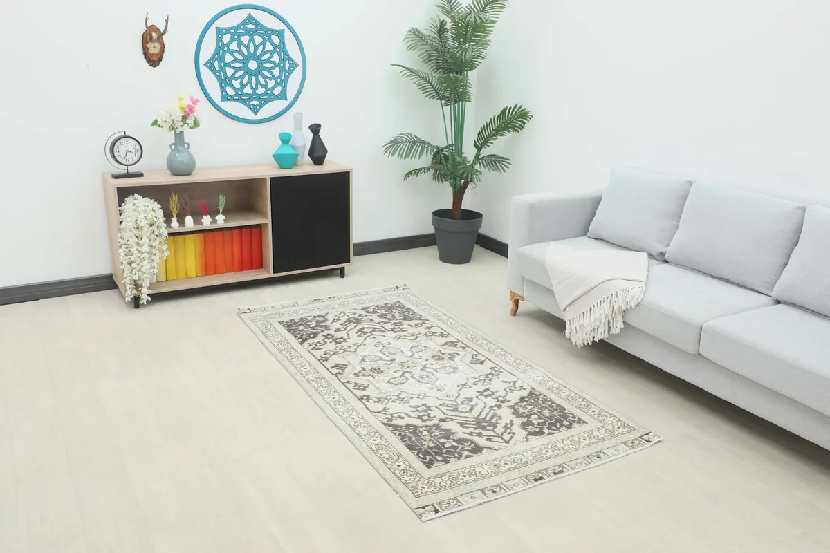 Cream and charcoal rug placed in a modern living room setting with a sofa