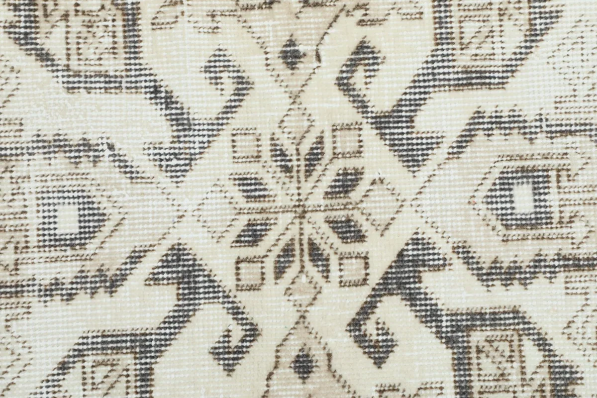Extreme close-up showing the wool pile texture and hand-knotted details of the rug