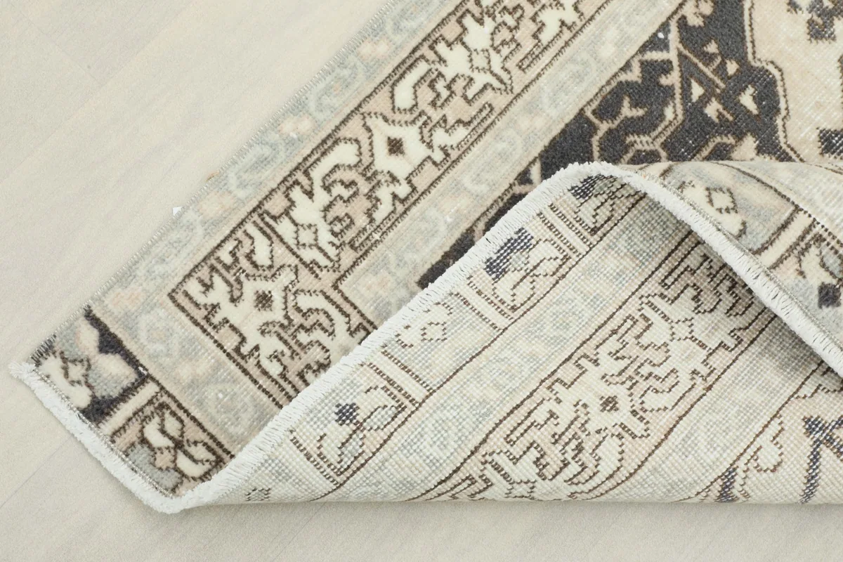 Underside view of the rug corner, revealing the cotton foundation and knotting