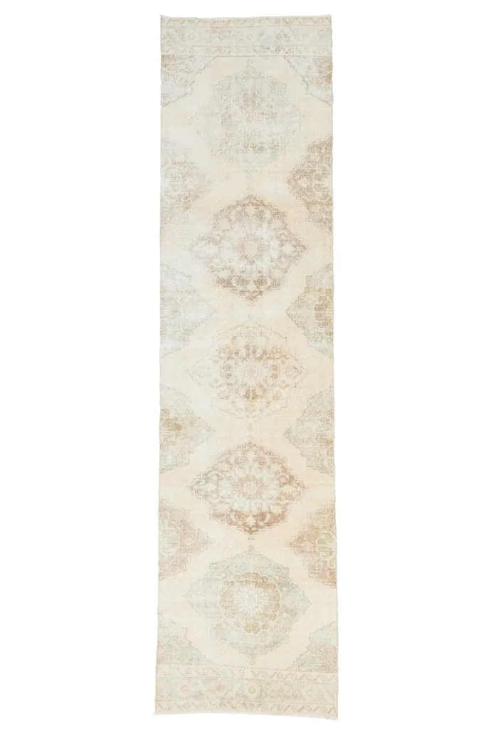 Overhead view of the entire 2'11" x 12'2" ivory runner rug, displaying its full design.