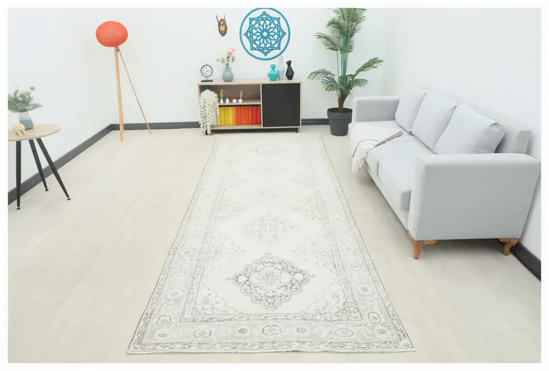 Full top view of the 4'7" x 11'11" ivory runner rug with gray and blue geometric medallions.