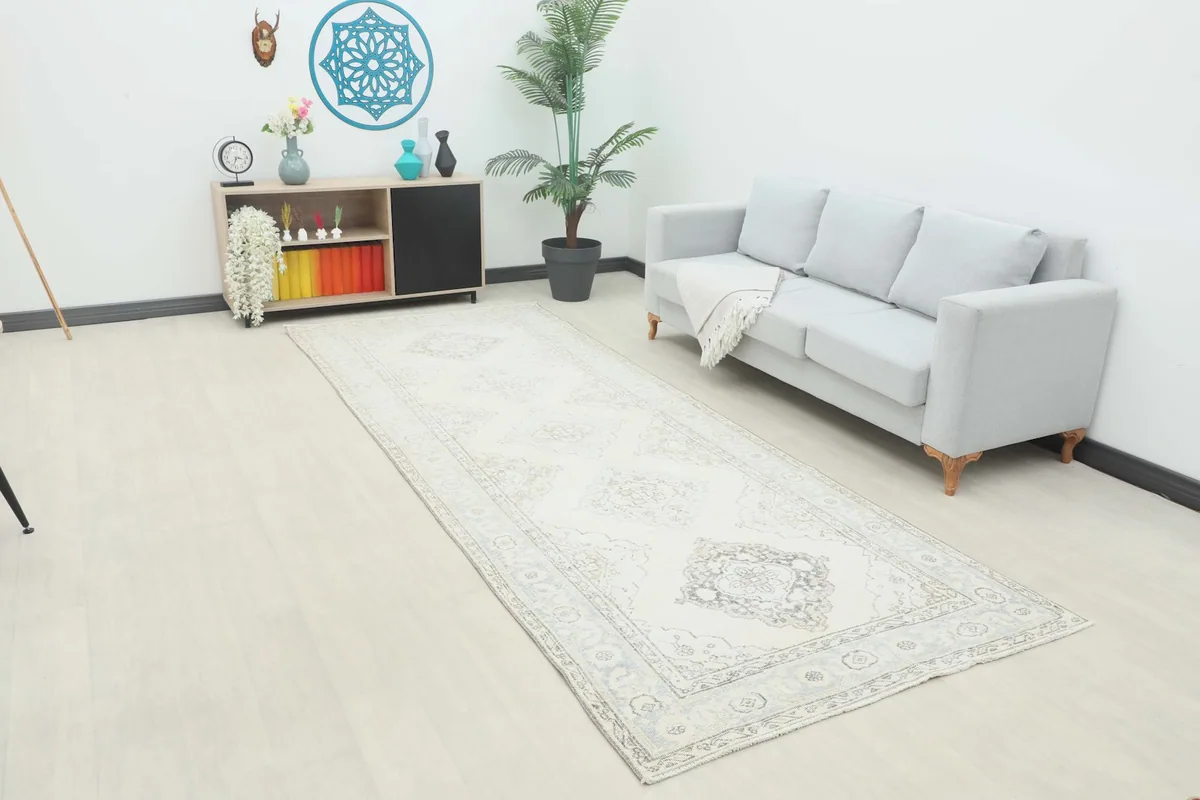 Ivory runner rug displayed in a room setting, showing its length and neutral tones.