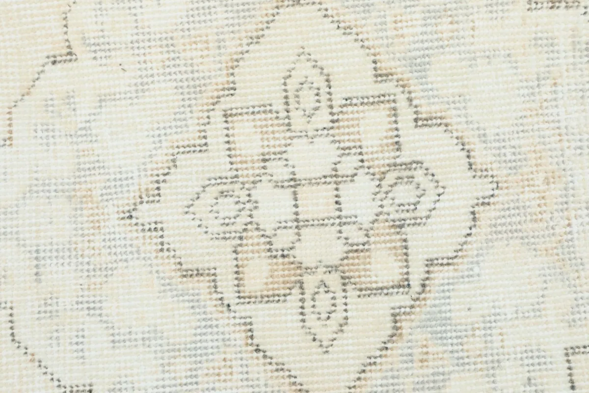 Close-up of a single gray and ivory medallion with a subtle blue undertone.