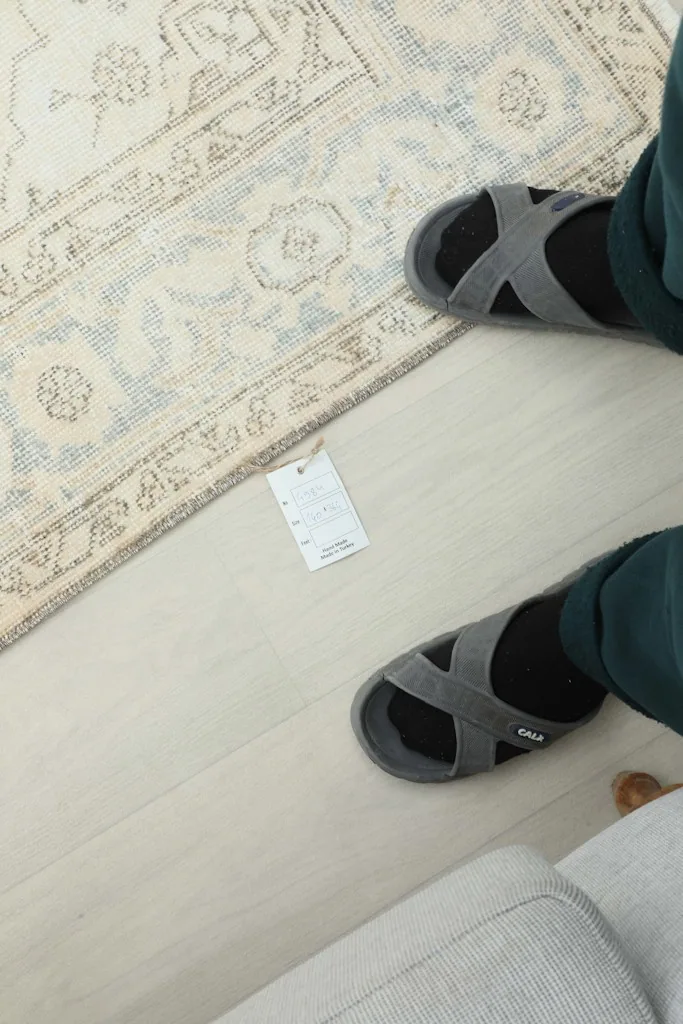 Feet standing near the rug, providing a sense of scale and showing the rug's texture.