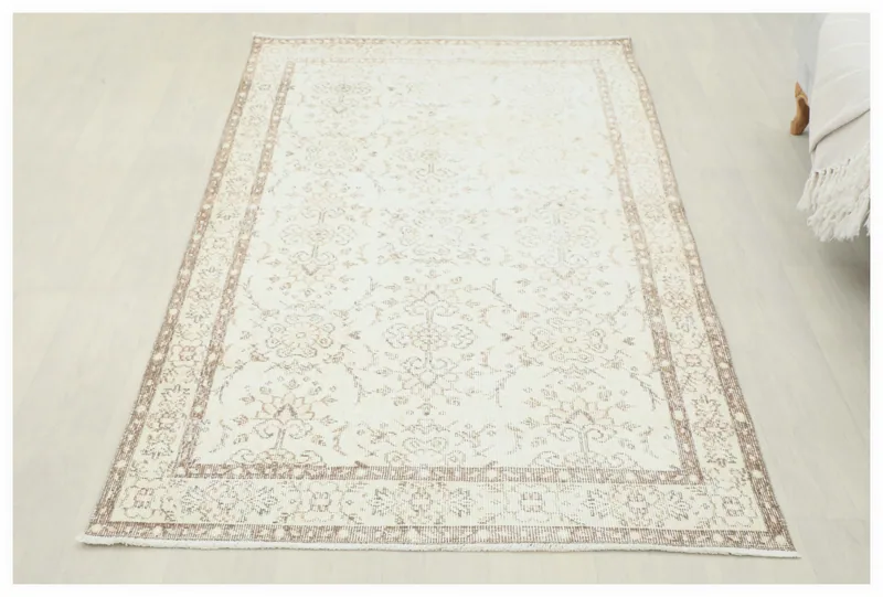 Full top view of the 4x7 ivory and tan floral vintage Anatolian area rug
