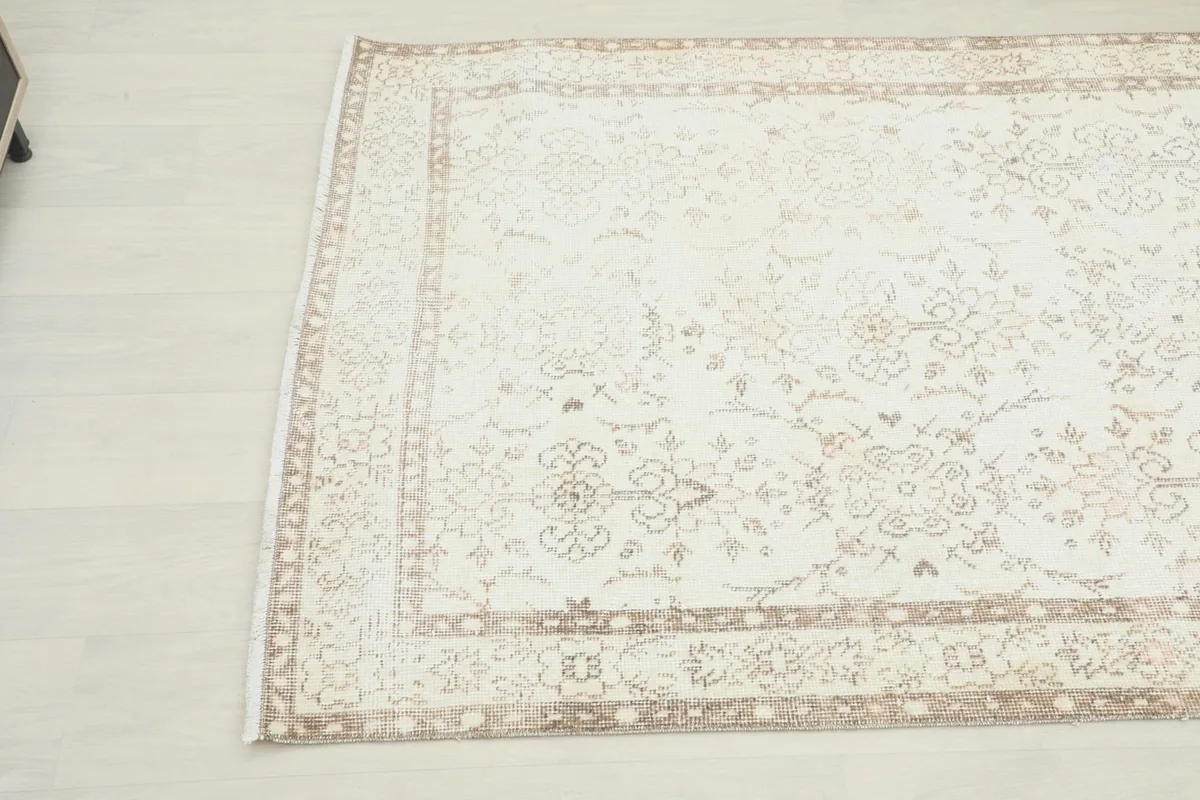 Overhead angle view highlighting the faded tan floral motifs and border design