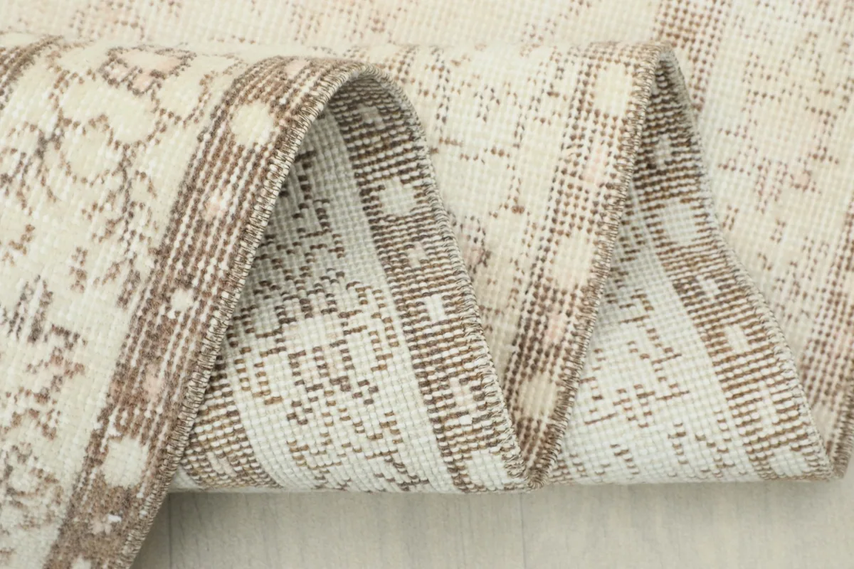 Close-up of the rug's low pile and intricate weaving, with a folded section