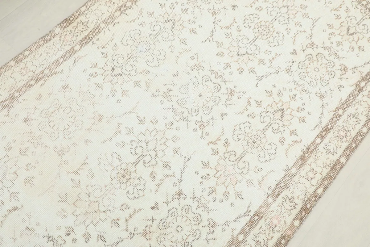 Overhead view focusing on the central floral patterns and gentle wear on the rug