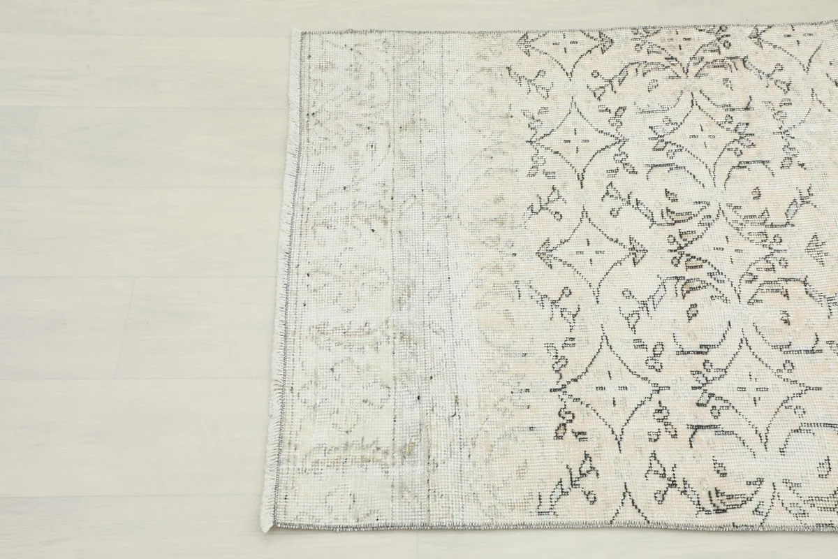 Detail showing the faded top section and the more prominent geometric pattern of the vintage rug.