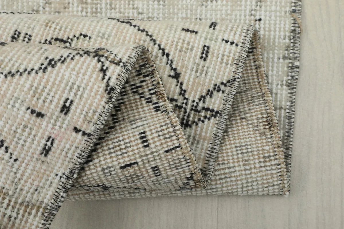 Close-up of the rug's back, showing the consistent hand-knotted cotton foundation.