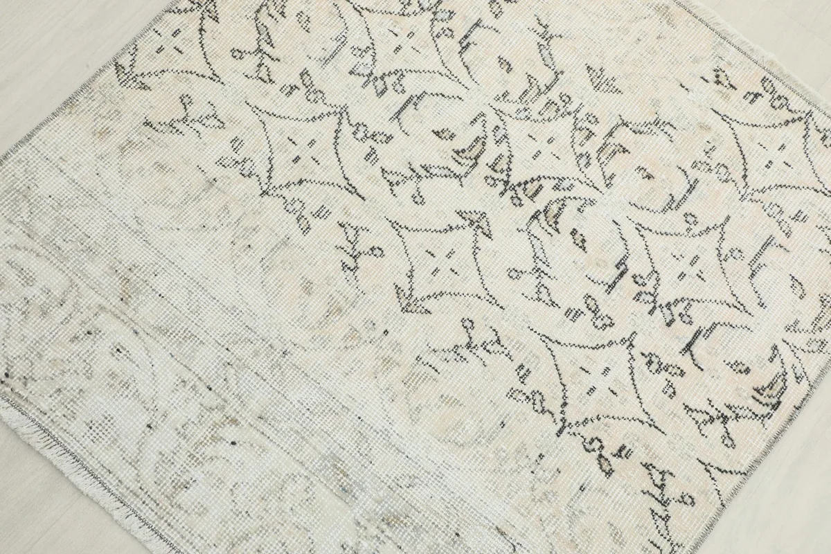 Overhead view focusing on the distinct geometric pattern and subtle color variations of the rug.
