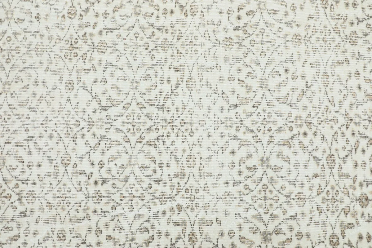 Detailed view of the ivory field with subtle floral and geometric motifs