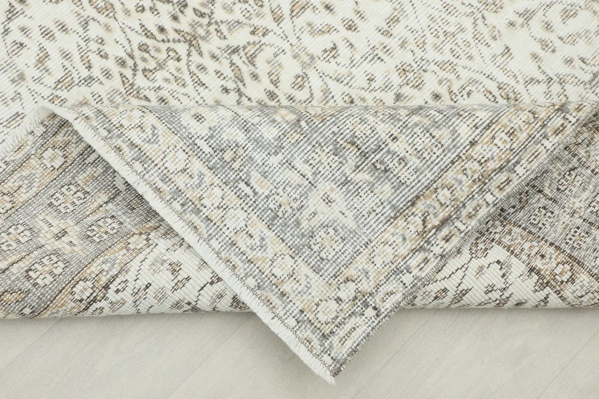 Folded corner of the rug revealing the cotton foundation and hand-knotted construction