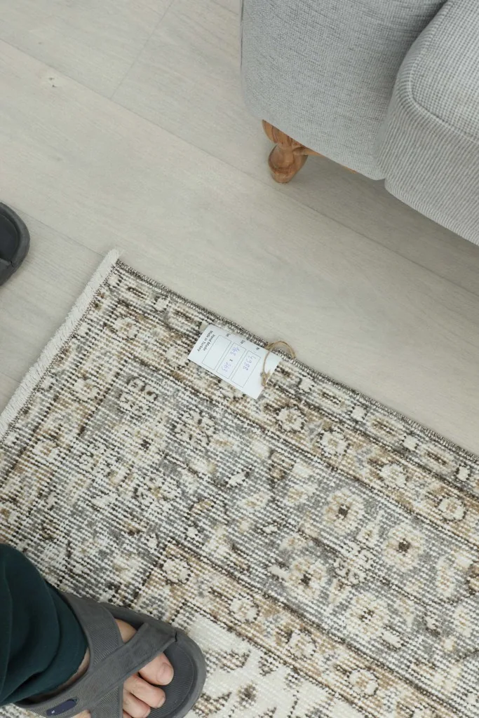 Overhead view of a section of the rug, providing a sense of scale with feet nearby