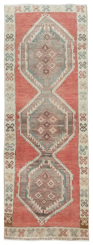 Full top view of the 3'2" x 9'5" vintage Anatolian runner with rust field and geometric medallions.
