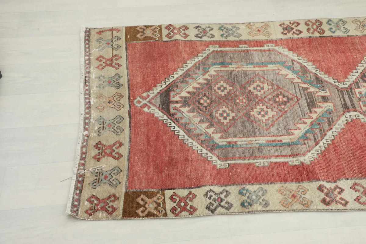 Detail of the runner's end, showcasing the tribal border design and the rust main field.