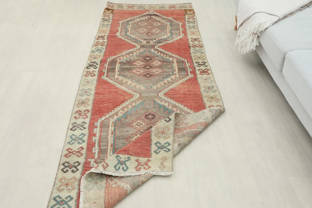 Full length view of the runner partially folded, demonstrating its flexibility and vintage patina.