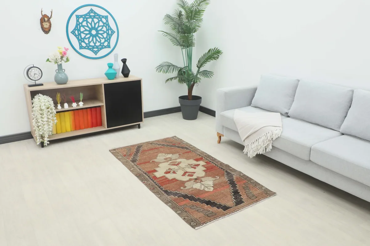 Overhead view of the small rust and red geometric rug placed in a modern living room setting.