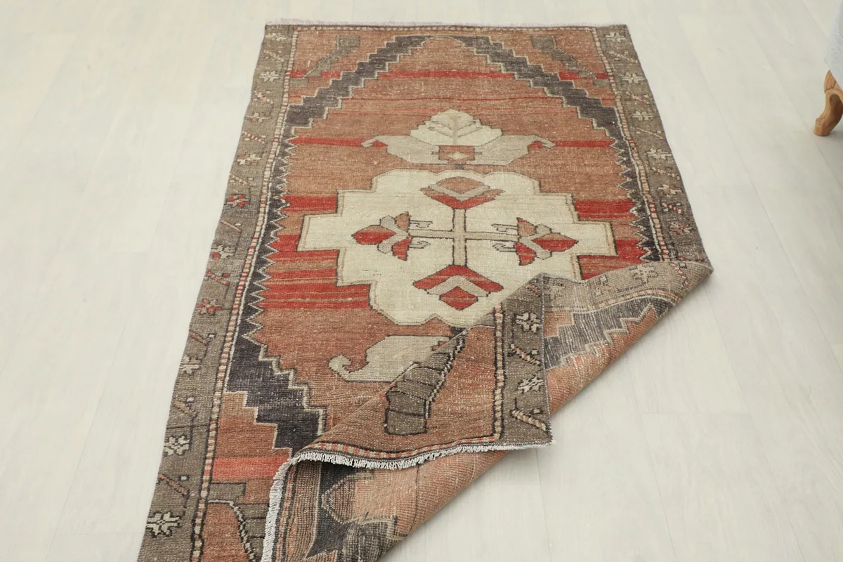 Angled view of the rug with one corner folded back, revealing the cotton foundation.