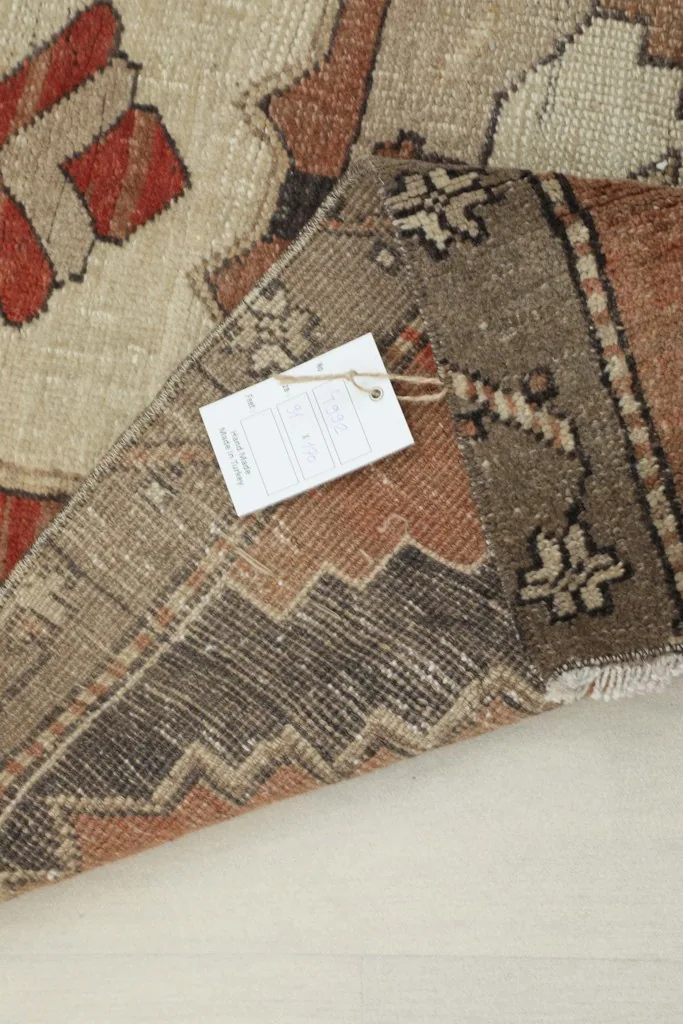 View of the rug with its product tag attached, showing the back and pile.