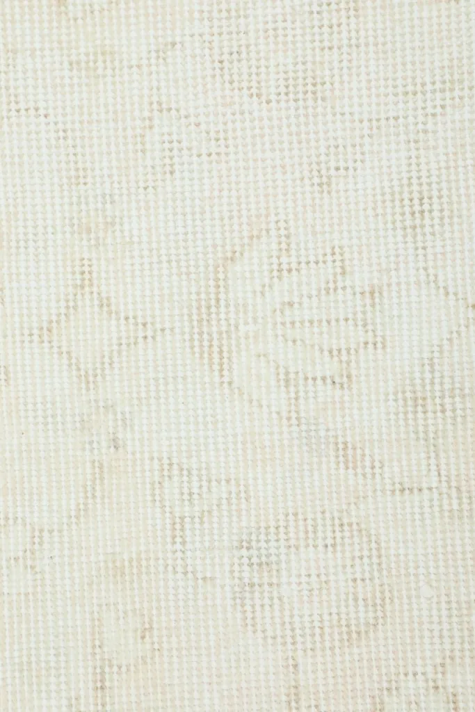 Close-up texture of the low wool pile, showing the hand-knotted construction and subtle color variations.