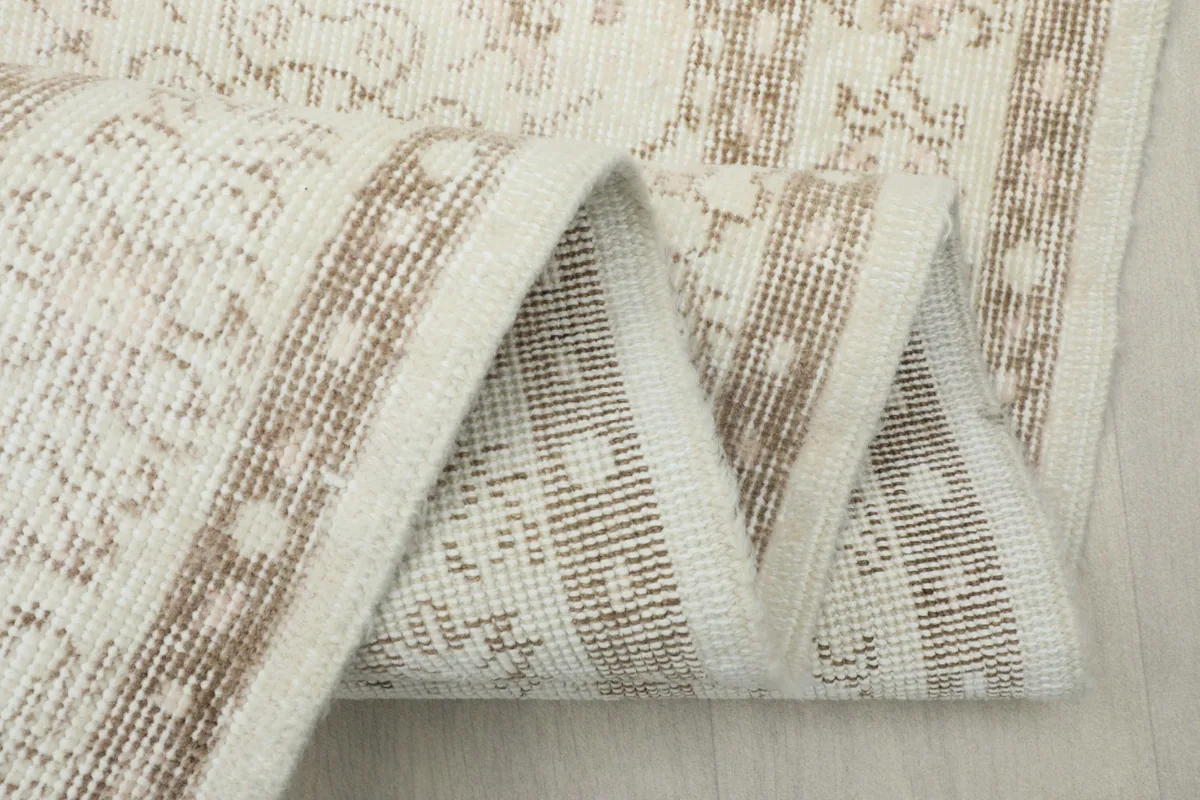 Close-up of the low wool pile and hand-knotted construction along the rug's edge