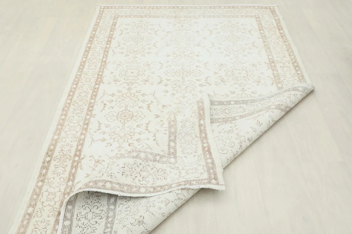 Folded corner of the rug, illustrating its flexibility and the wool pile on cotton base