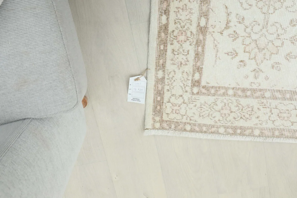 Partial view of the rug next to a sofa, with a product tag visible on the floor