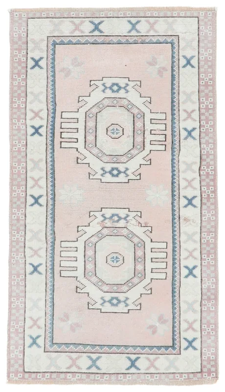 Full overhead view of the pink and ivory geometric medallion rug on a white background