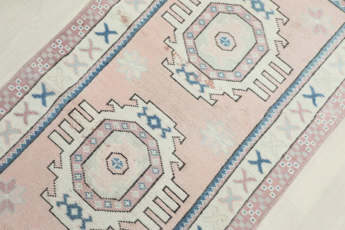 Detail view from an angle, showcasing the two central ivory medallions on the pink field