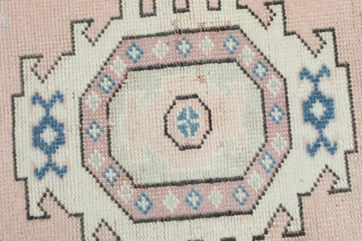 Detailed shot of a central ivory medallion with its intricate blue and pink geometric elements