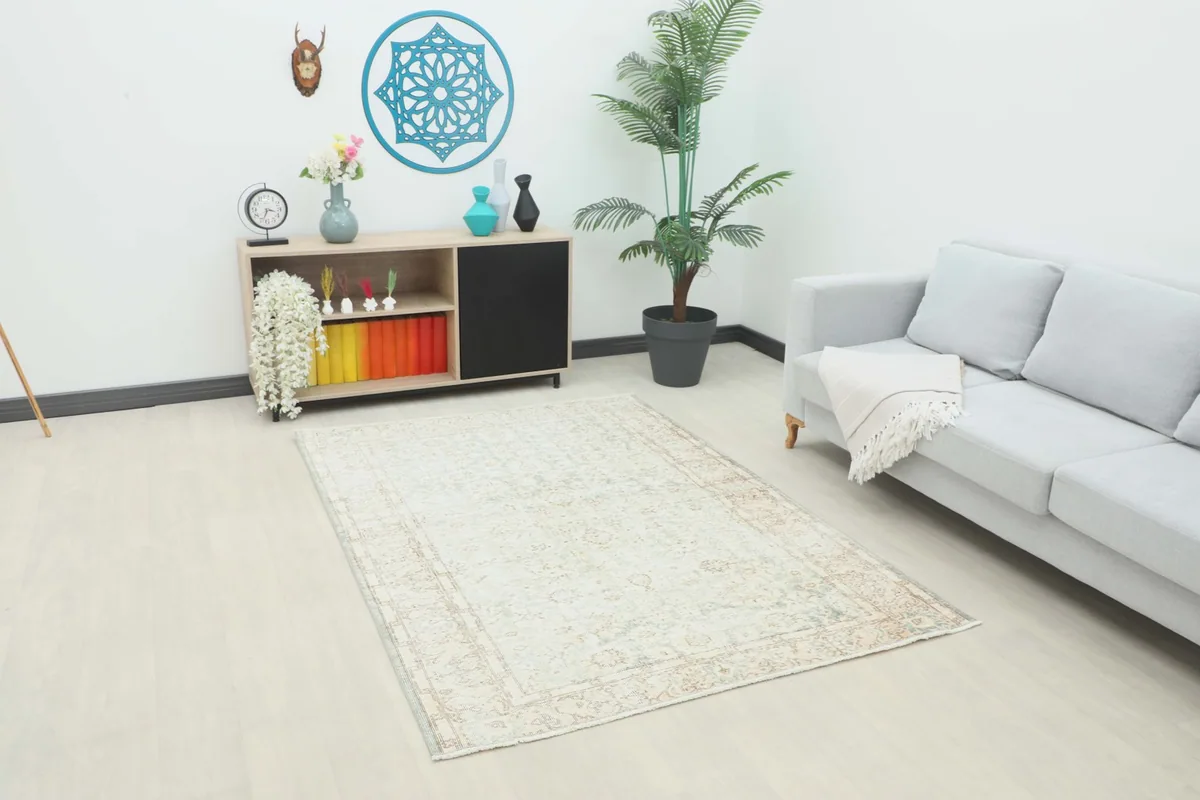 Vintage Anatolian rug displayed in a modern living room setting with a light gray sofa and wooden cabinet.