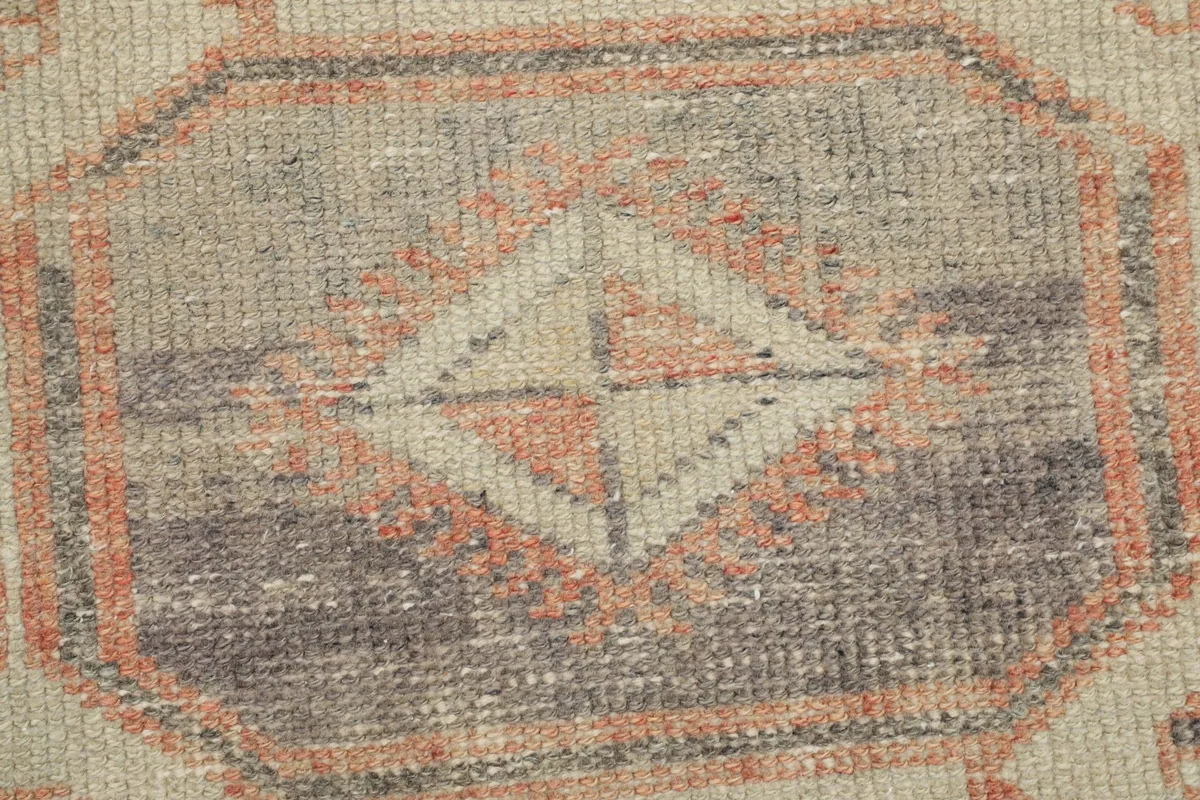 Extreme close-up of a geometric motif, showing wool pile texture and knotting