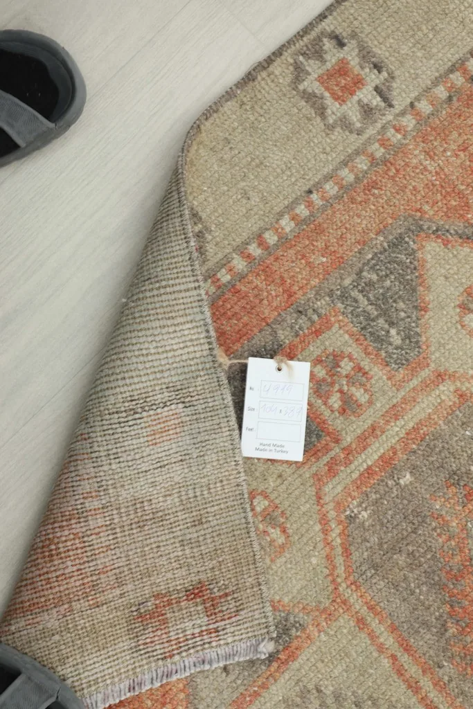 Corner of the runner with a tag, showing the reverse side and fringes