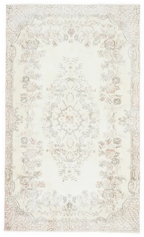 Full overhead view of the ivory and rose floral medallion vintage Anatolian rug on a white background