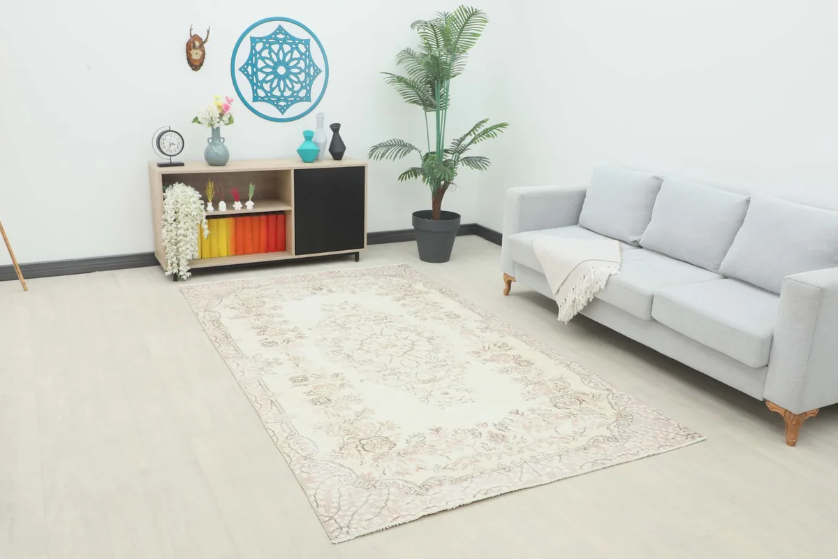 Vintage Anatolian rug placed in a modern living room setting with a light gray sofa and wooden console