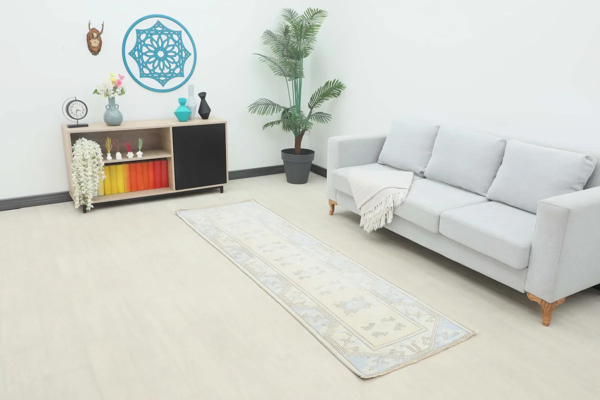 Ivory and blue vintage Anatolian runner placed in a modern living room setting