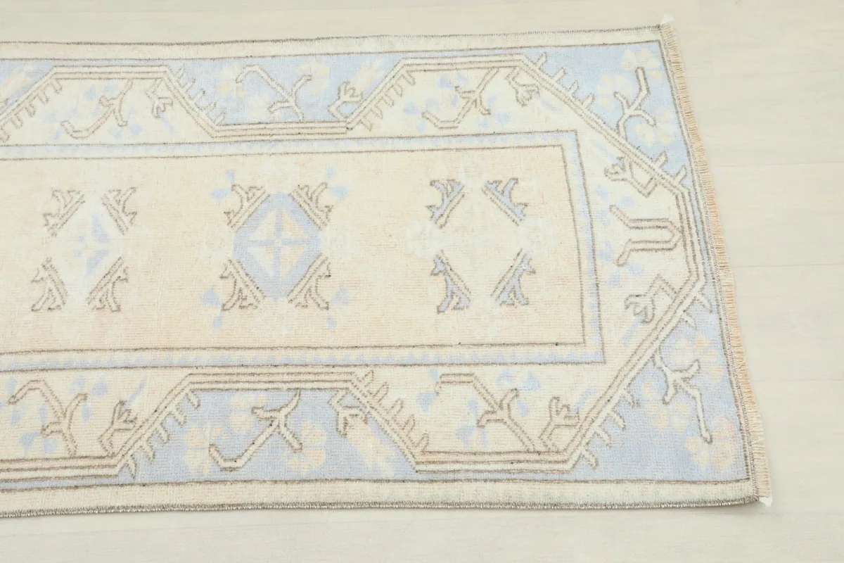 Close-up detail of one end of the runner, showing the ivory field and blue border design