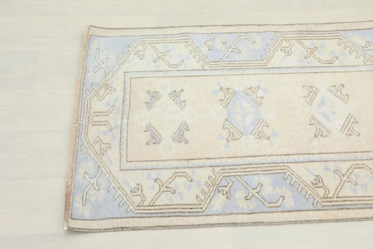 Detail view of the rug's pattern and colors, including the geometric motifs and beige outlines