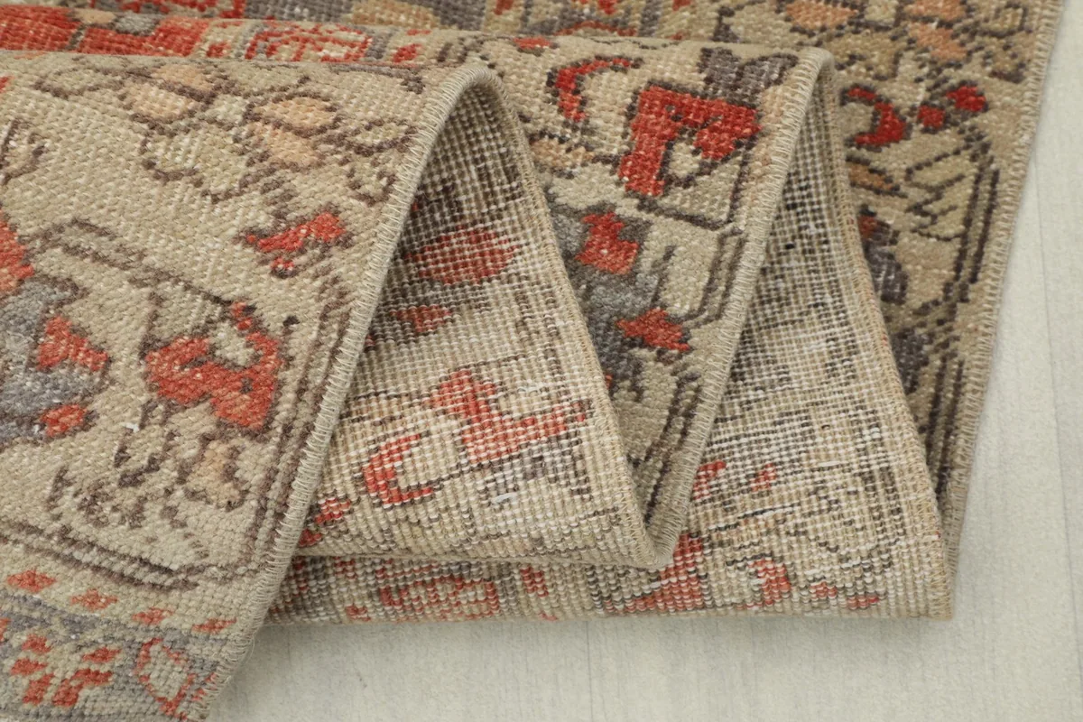 Close-up of the rug's folded edge, illustrating the low pile and intricate weave.