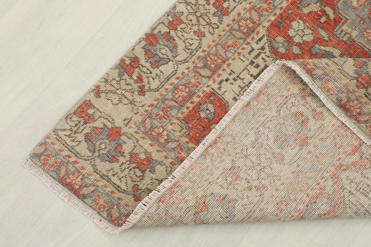 Corner of the rug folded to reveal the hand-knotted wool pile and cotton foundation.