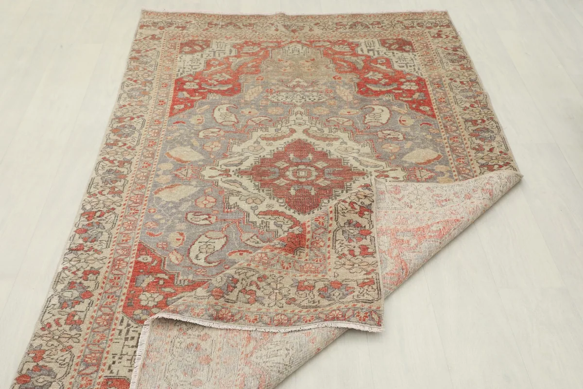 Rug partially folded, displaying the back and the soft texture of the vintage wool.